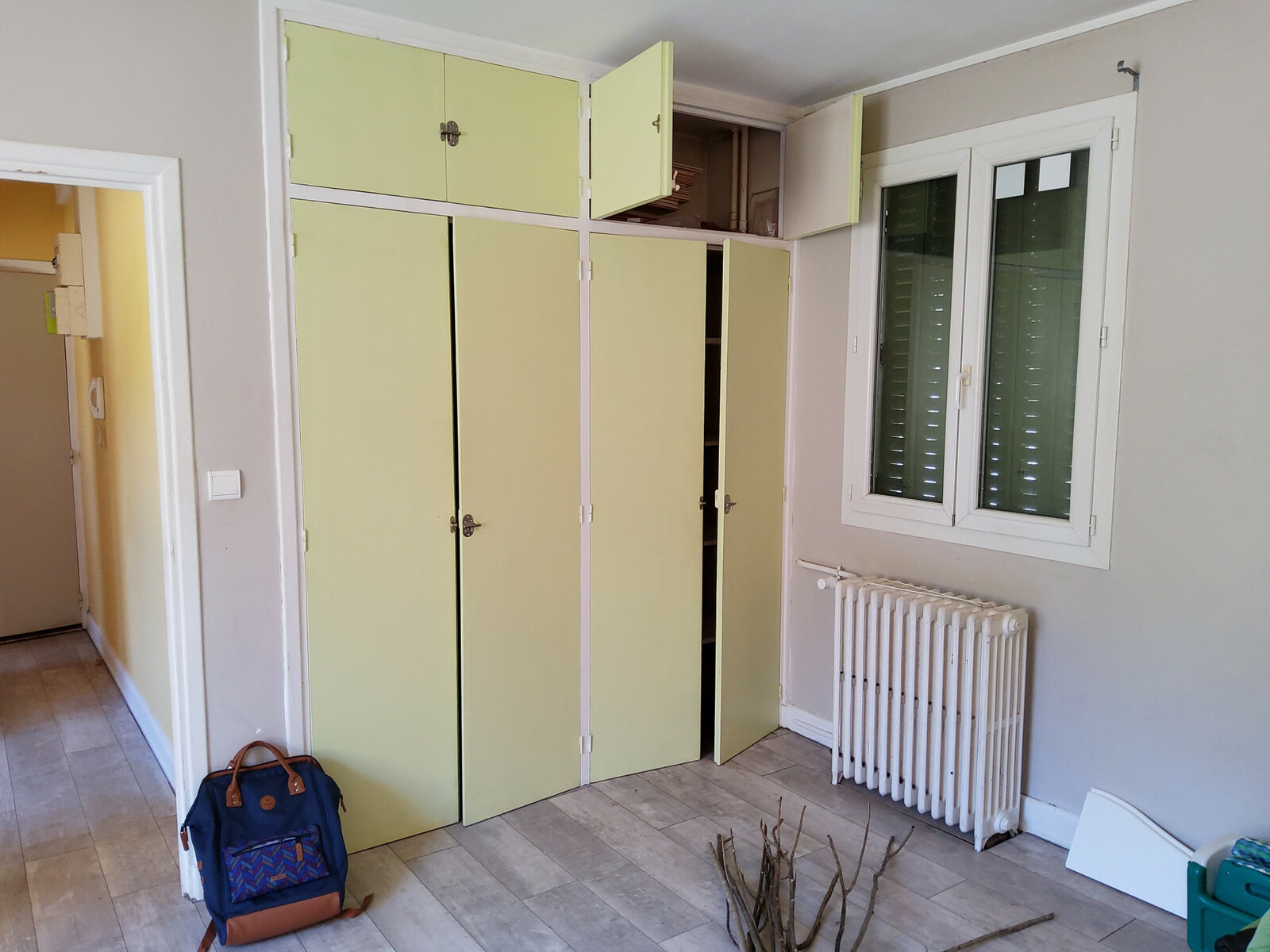 avant on voit une pièce fade avec portes de placard jaunes pales